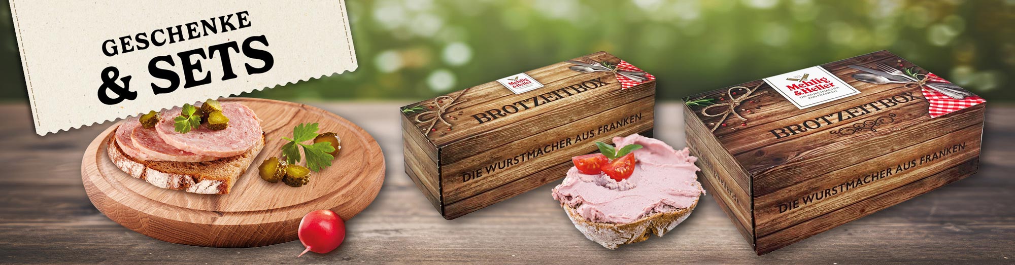 Label mit dem Text "GESCHENKE & SETS". Zusehen ist zwei belegte Brote und zwei Geschenke Boxen von "Mehlig & Heller".
