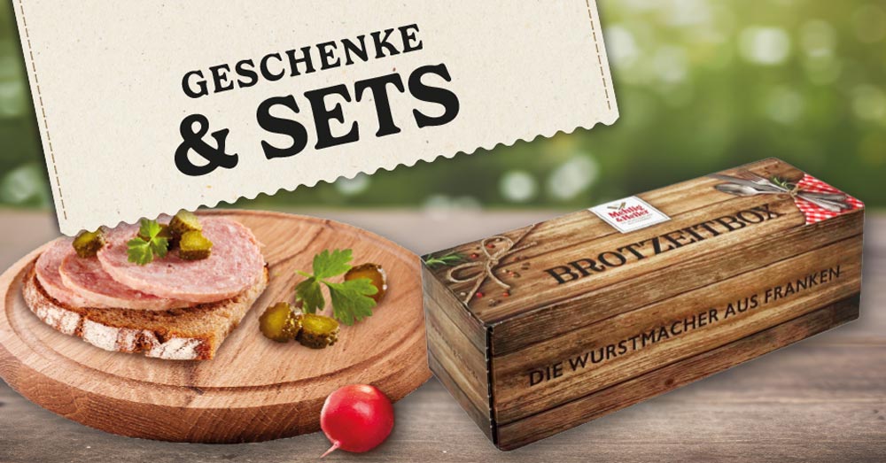 Label mit dem Text "GESCHENKE & SETS". Zusehen ist ein belegtes Brot und eine Geschenke Box von "Mehlig & Heller".