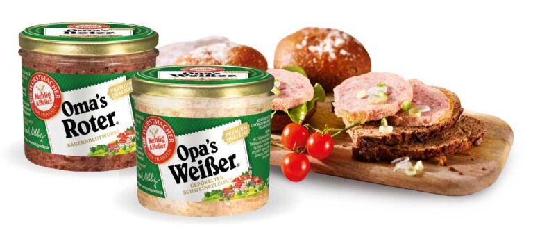 Ein Glas "Oma's Roter" und ein Glas "Opa's Weißer" von "Mehlig & Heller", dahinter ein Schneidebrett mit einem Belegten Brot.